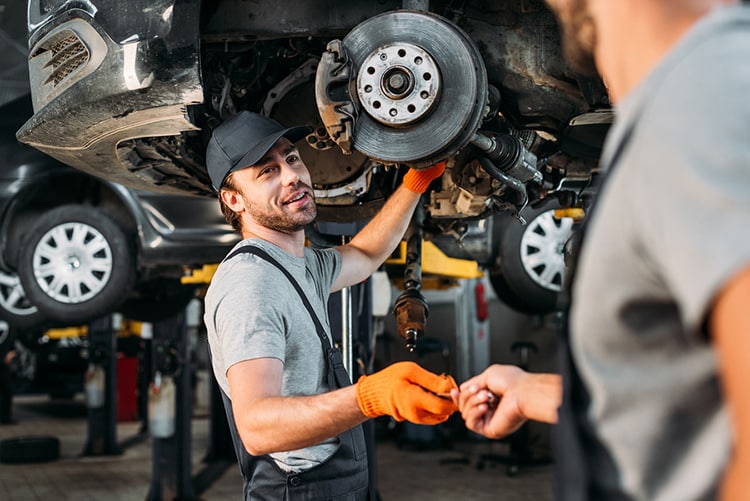 repairing car without wheel in mechanic shop